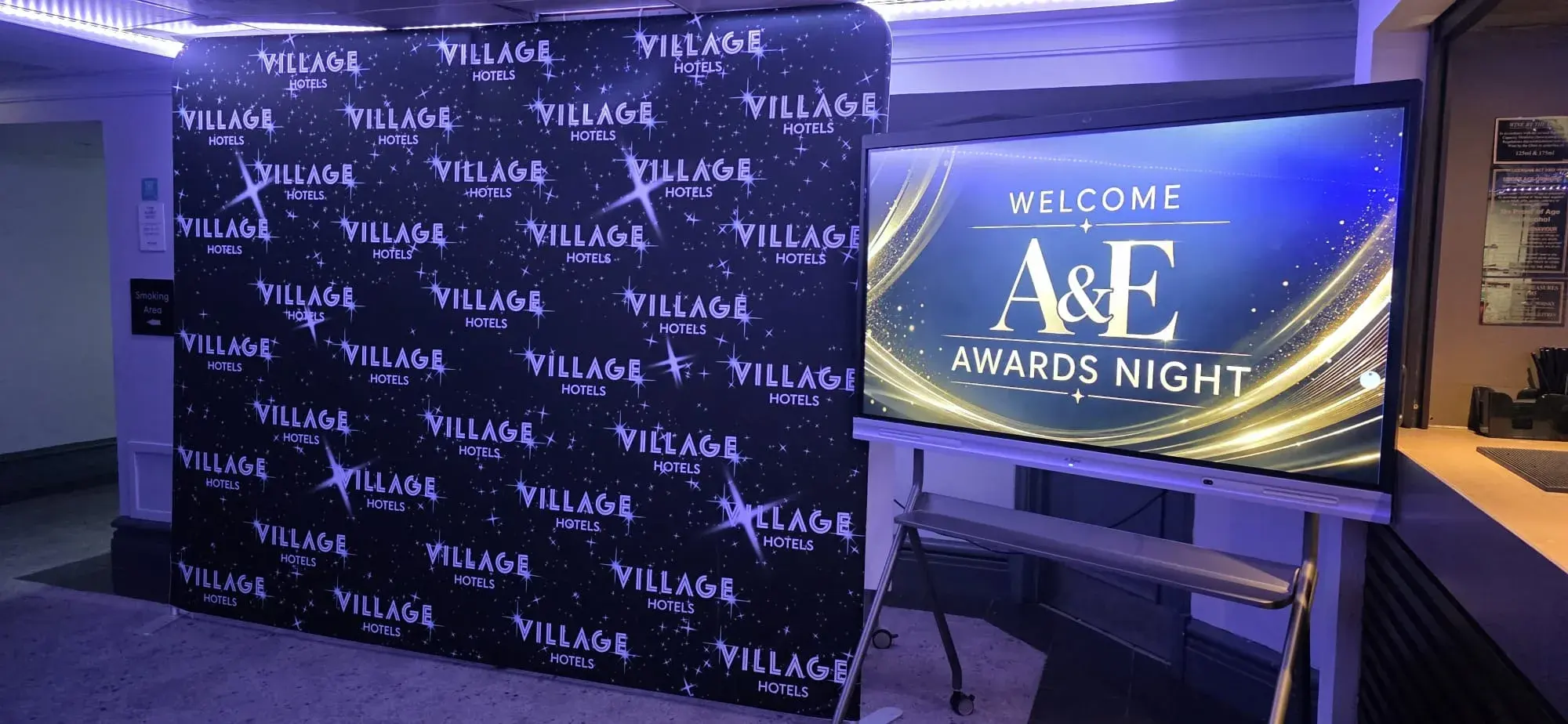 An awards-night welcome screen beside a Village Hotels backdrop